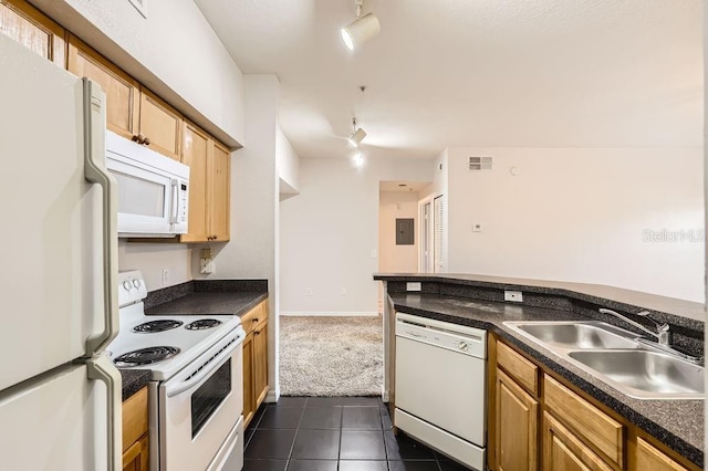 kitchen with dark countertops, white appliances, dark tile patterned floors, and a sink