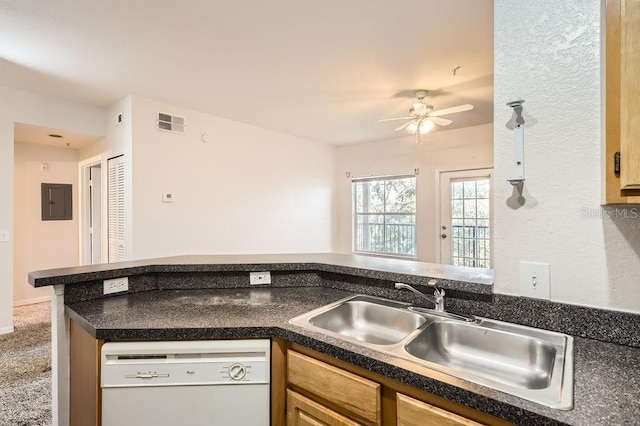 kitchen featuring dark countertops, white dishwasher, visible vents, and a sink