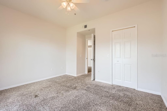 unfurnished bedroom featuring carpet, a closet, visible vents, ceiling fan, and baseboards