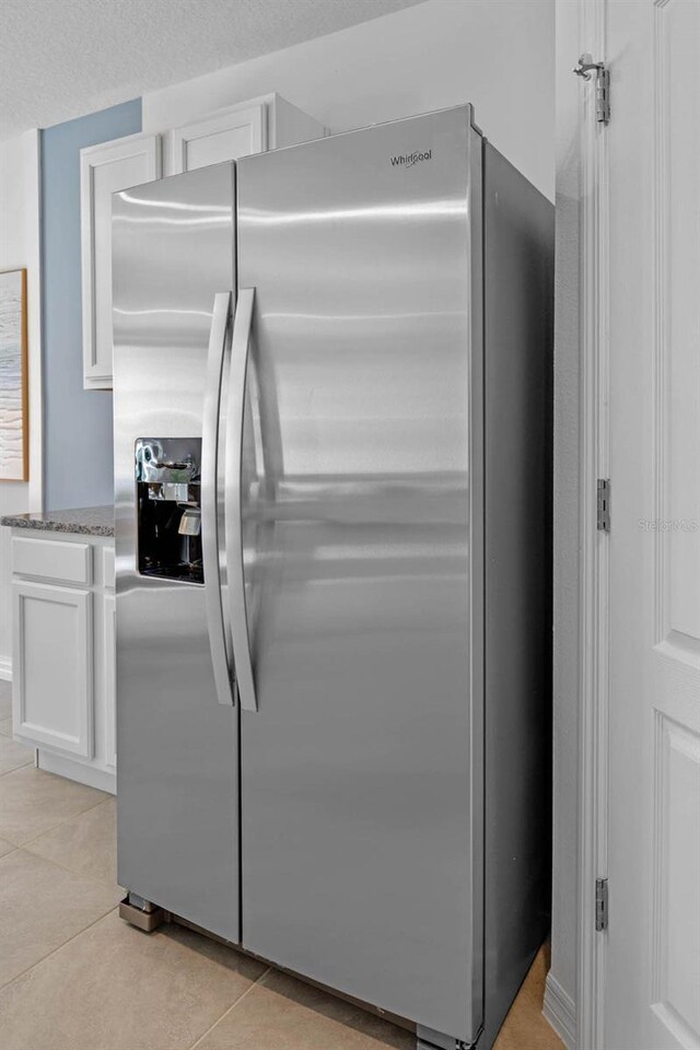 interior details with stainless steel refrigerator with ice dispenser and white cabinets