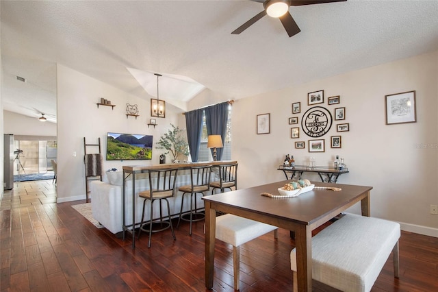 dining area with ceiling fan with notable chandelier, baseboards, lofted ceiling, and hardwood / wood-style floors