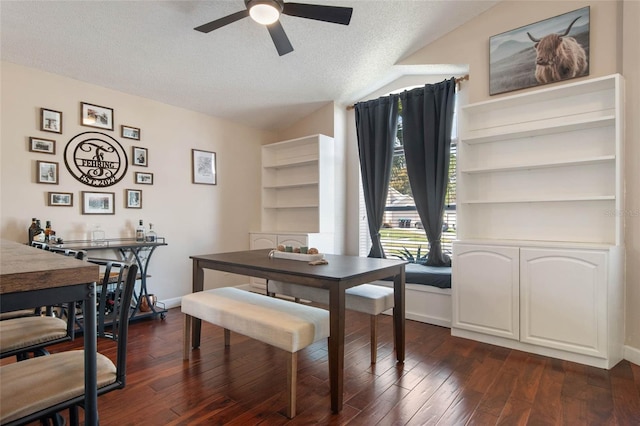 dining room with a ceiling fan, lofted ceiling, dark wood-style floors, and a textured ceiling