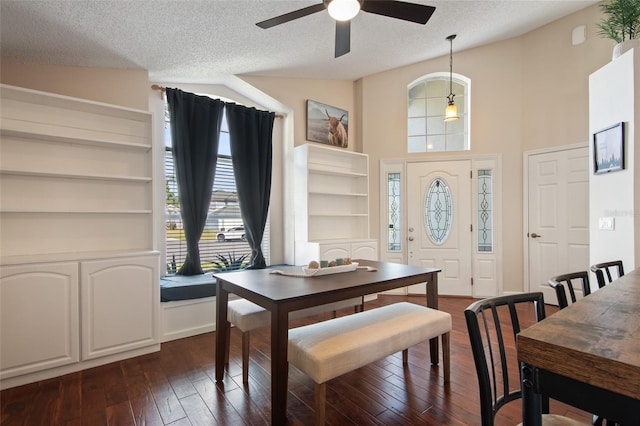 dining space featuring vaulted ceiling, a textured ceiling, a ceiling fan, and dark wood-style flooring