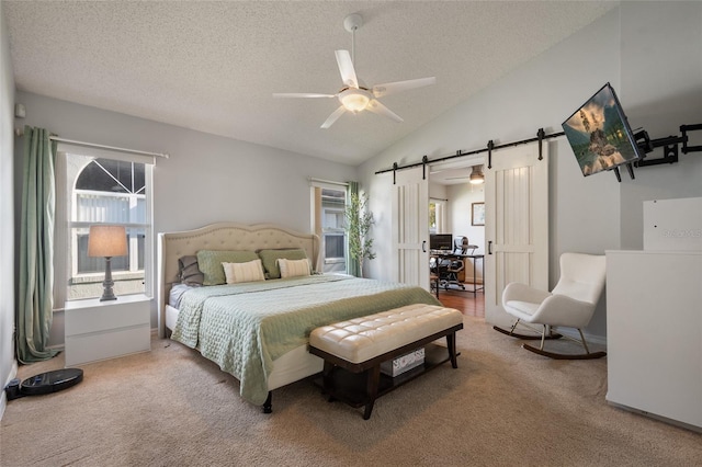 bedroom with a textured ceiling, a barn door, carpet floors, and vaulted ceiling