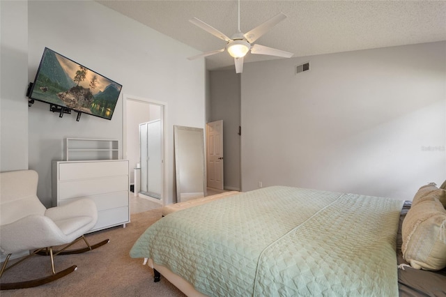 carpeted bedroom with visible vents, a textured ceiling, and a ceiling fan