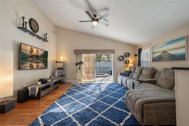 living room with visible vents, a textured ceiling, wood finished floors, lofted ceiling, and ceiling fan