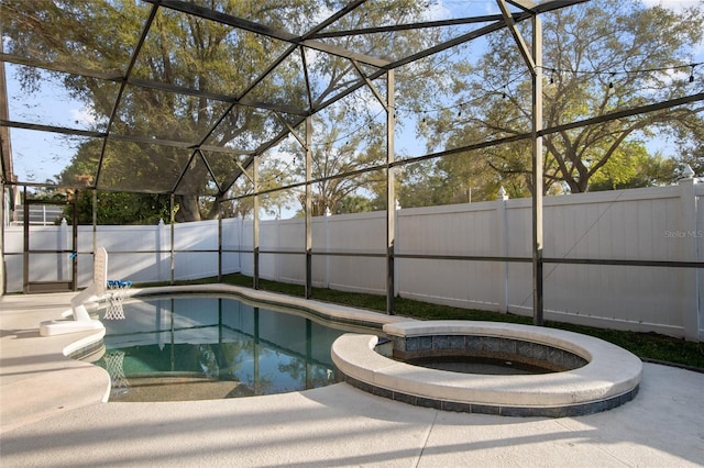 view of swimming pool with a lanai, a fenced backyard, and a pool with connected hot tub