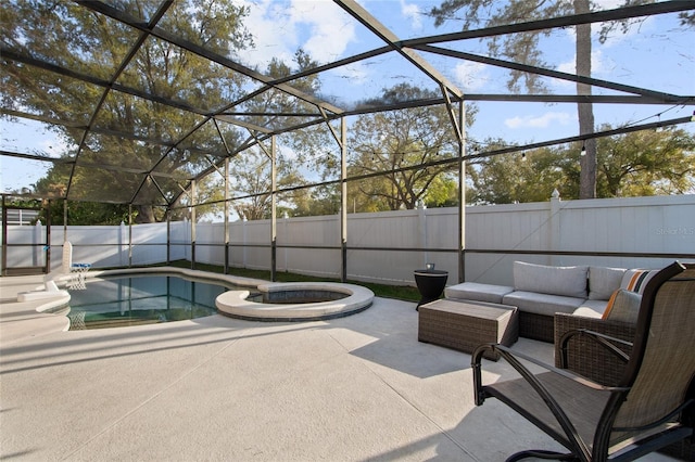 view of swimming pool featuring a pool with connected hot tub, an outdoor living space, a fenced backyard, glass enclosure, and a patio area