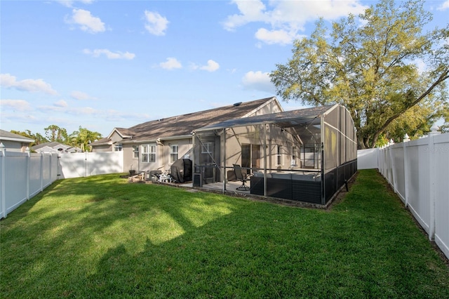 rear view of house featuring a lanai, a fenced backyard, a lawn, and a patio