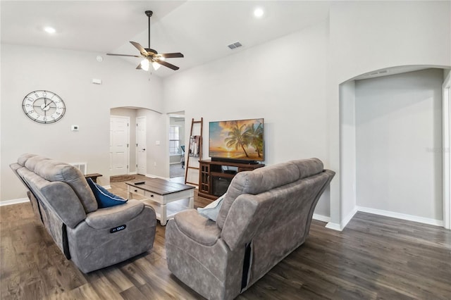 living area with visible vents, baseboards, vaulted ceiling, dark wood-style floors, and arched walkways