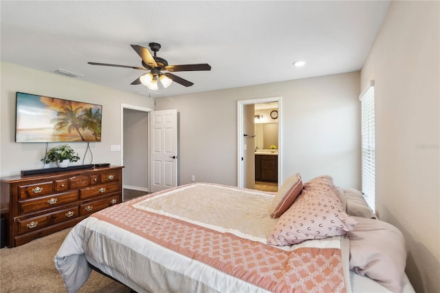 carpeted bedroom featuring a ceiling fan, visible vents, and ensuite bathroom