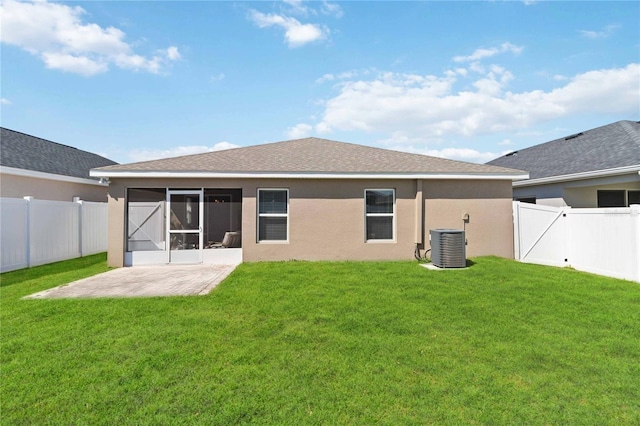 rear view of house featuring cooling unit, a fenced backyard, and a yard