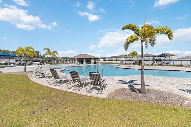 community pool with a yard, a patio, a residential view, and fence