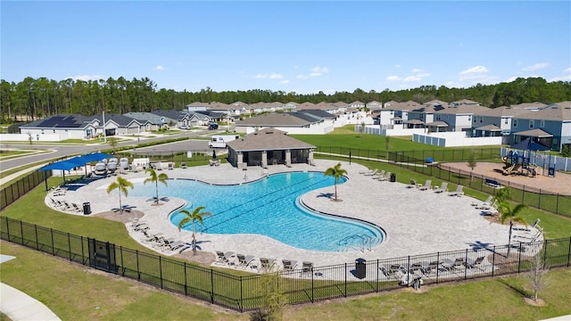 pool with a patio area, a residential view, and fence