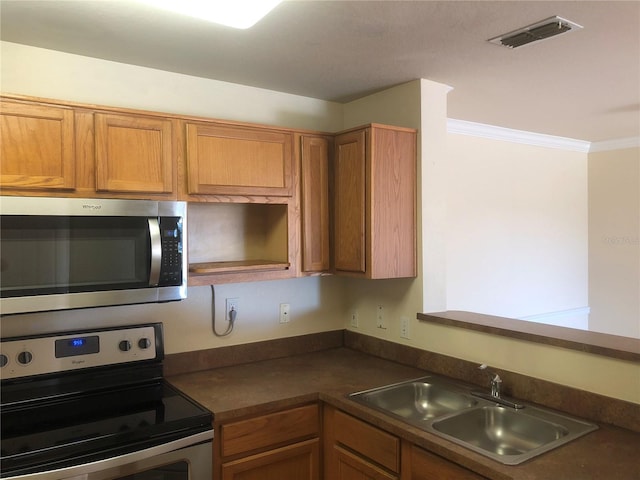 kitchen with visible vents, dark countertops, ornamental molding, stainless steel appliances, and a sink