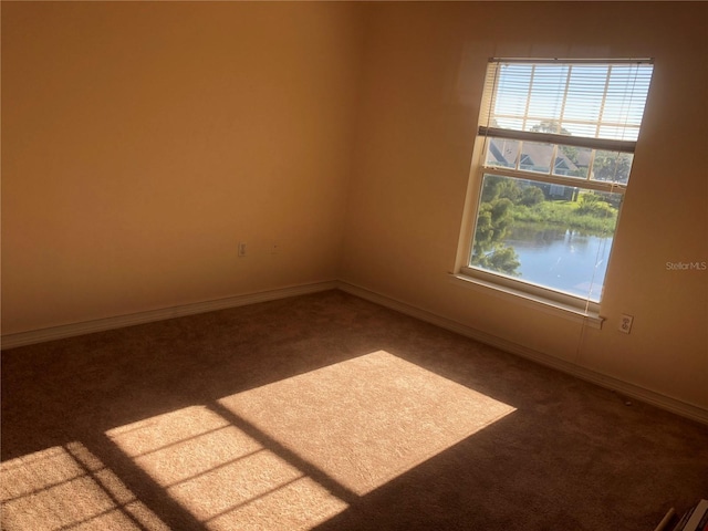 carpeted empty room with baseboards