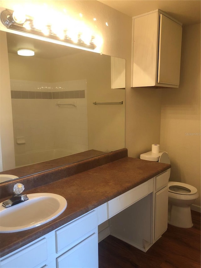 full bathroom with toilet, wood finished floors, and vanity