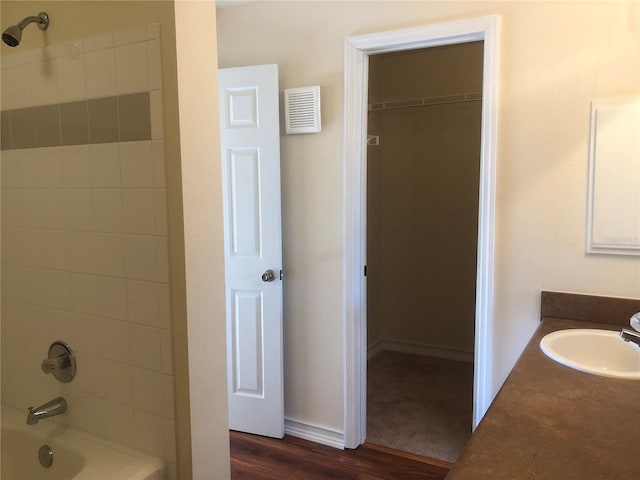 full bathroom with shower / tub combination, wood finished floors, vanity, visible vents, and baseboards