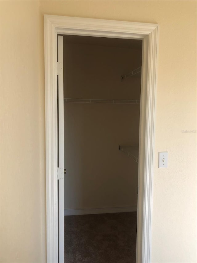 corridor with carpet floors and baseboards