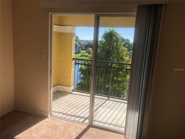 doorway to outside featuring carpet flooring and baseboards