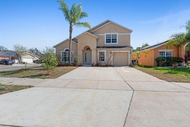 view of front of home with a garage, driveway, and stucco siding