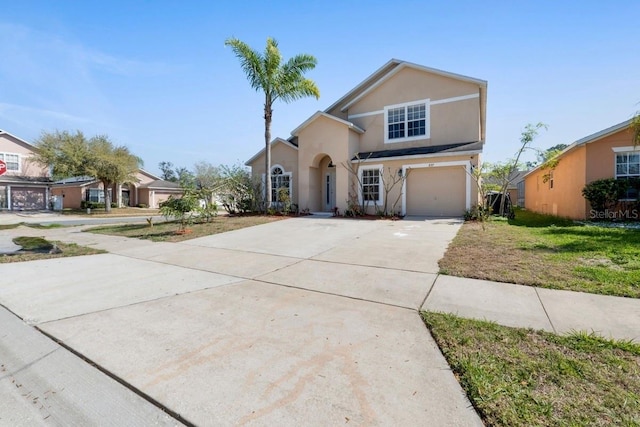 view of front facade with a garage, driveway, and stucco siding