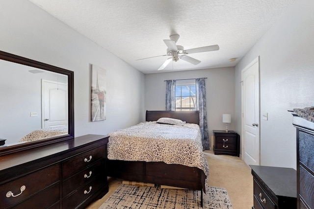 bedroom featuring a textured ceiling, a ceiling fan, and light colored carpet