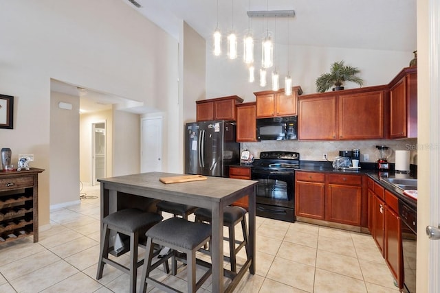 kitchen featuring light tile patterned floors, decorative backsplash, dark countertops, a towering ceiling, and black appliances