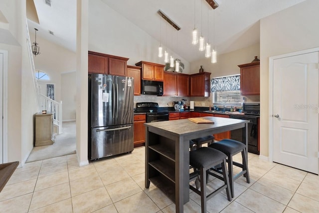 kitchen featuring pendant lighting, light tile patterned floors, dark countertops, decorative backsplash, and black appliances