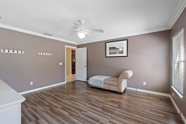 unfurnished room featuring ornamental molding, wood finished floors, visible vents, and baseboards