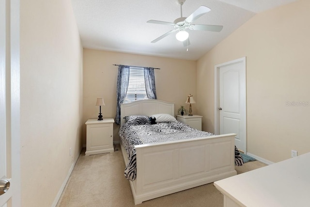 bedroom with vaulted ceiling, light carpet, a ceiling fan, and baseboards