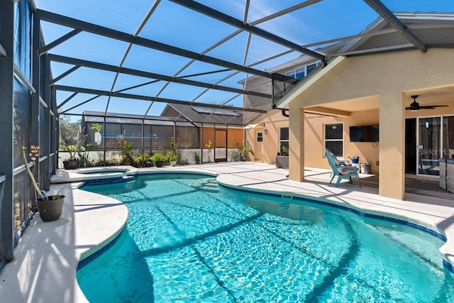 view of swimming pool featuring glass enclosure, a patio area, ceiling fan, and a pool with connected hot tub