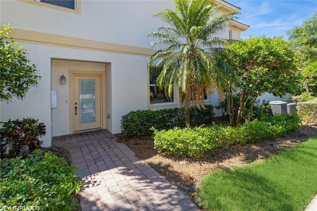 doorway to property featuring stucco siding