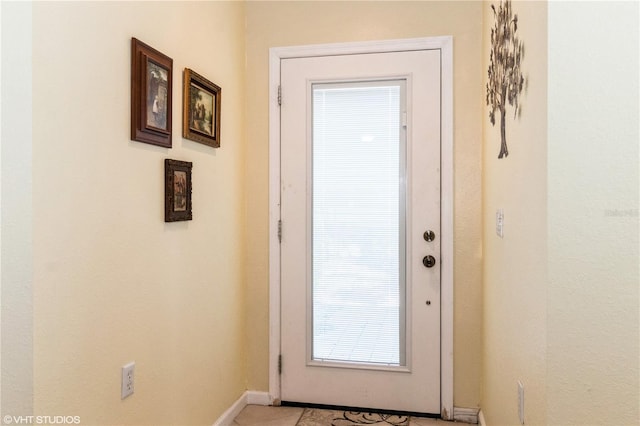 doorway featuring baseboards