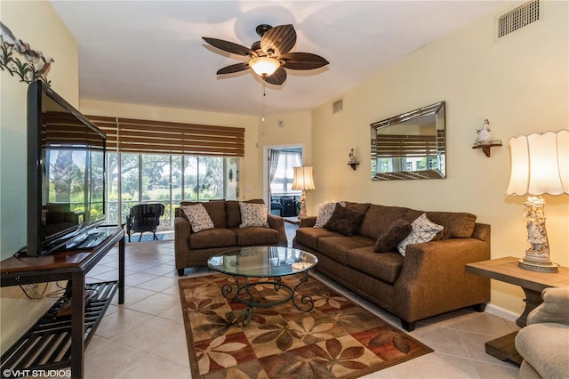 living room featuring a ceiling fan, a sunroom, visible vents, and light tile patterned floors