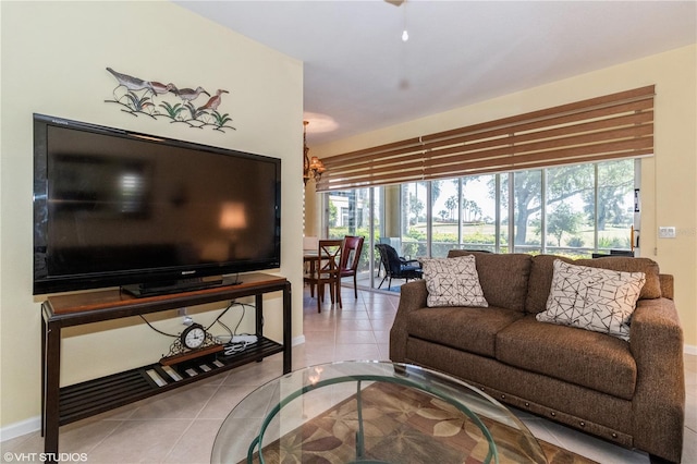 tiled living area with baseboards and an inviting chandelier