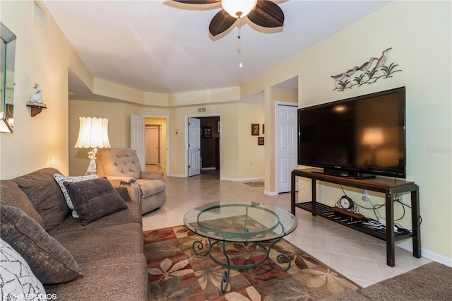 tiled living room featuring ceiling fan, visible vents, and baseboards