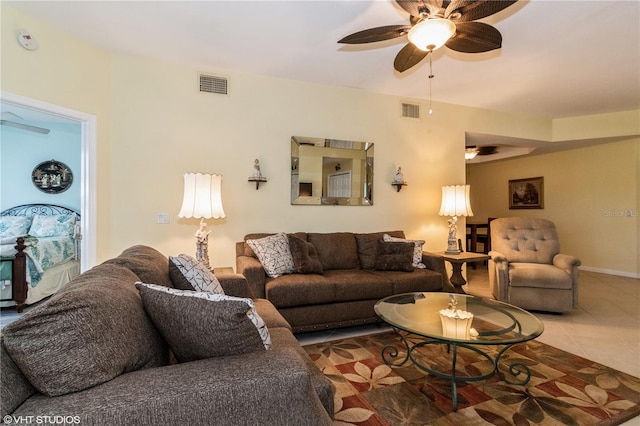 living area with baseboards, a ceiling fan, visible vents, and tile patterned floors