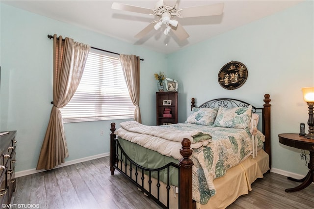 bedroom featuring wood finished floors, a ceiling fan, and baseboards