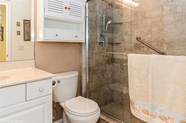 bathroom featuring toilet, tiled shower, and vanity