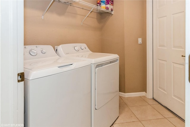 laundry room featuring laundry area, light tile patterned floors, baseboards, and washer and dryer