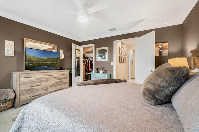 bedroom with a walk in closet, a closet, visible vents, ornamental molding, and carpet flooring