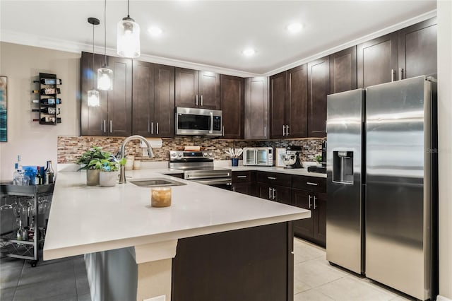 kitchen with stainless steel appliances, a sink, a peninsula, and dark brown cabinetry