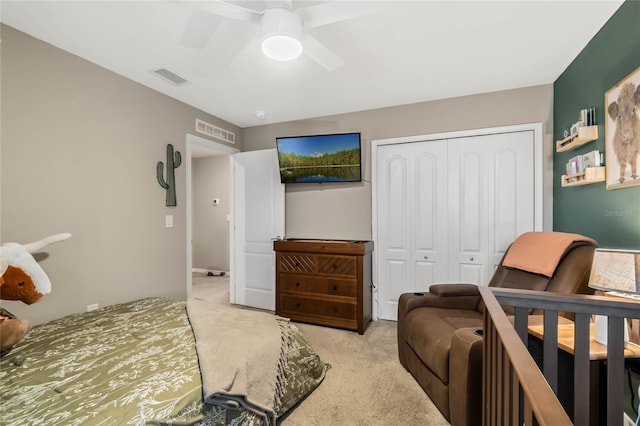 carpeted bedroom with a closet, visible vents, and ceiling fan