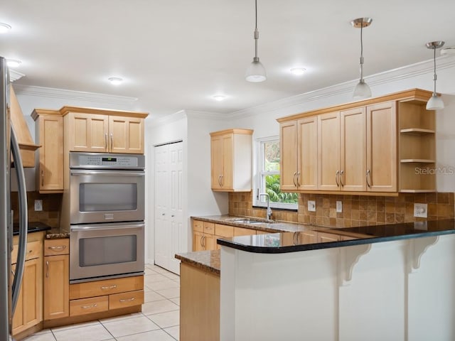 kitchen featuring light tile patterned floors, stainless steel appliances, light brown cabinets, a sink, and a peninsula