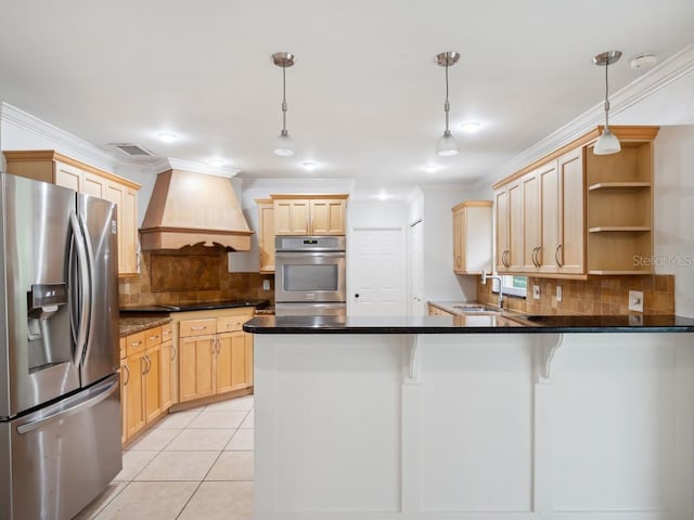 kitchen with premium range hood, appliances with stainless steel finishes, a sink, and light brown cabinetry