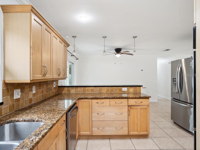 kitchen featuring backsplash, appliances with stainless steel finishes, light brown cabinets, light tile patterned flooring, and a peninsula