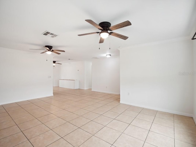 spare room with ceiling fan, visible vents, and baseboards