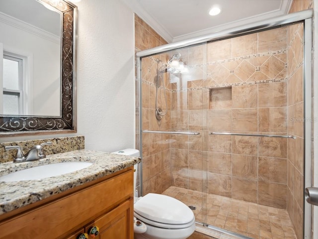 full bathroom featuring vanity, ornamental molding, a shower stall, and toilet