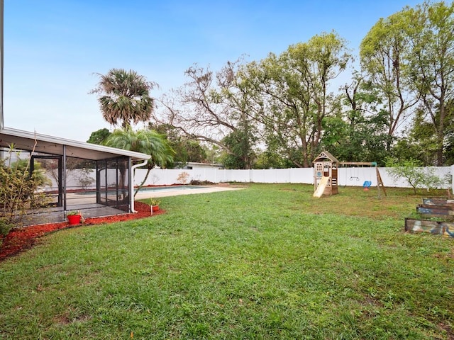 view of yard featuring a fenced in pool, a sunroom, a fenced backyard, and a playground